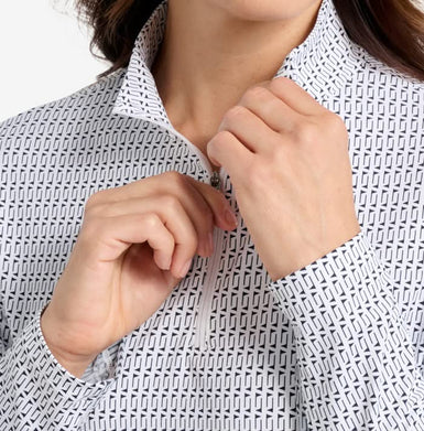 Person wearing a white shirt with black geometric pattern, adjusting collar.