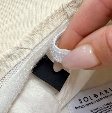 Close-up of a hand adjusting an internal hat adjuster with 'SOLBARI' branding.
