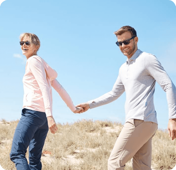 Two people holding hands on a clear day with a blue sky